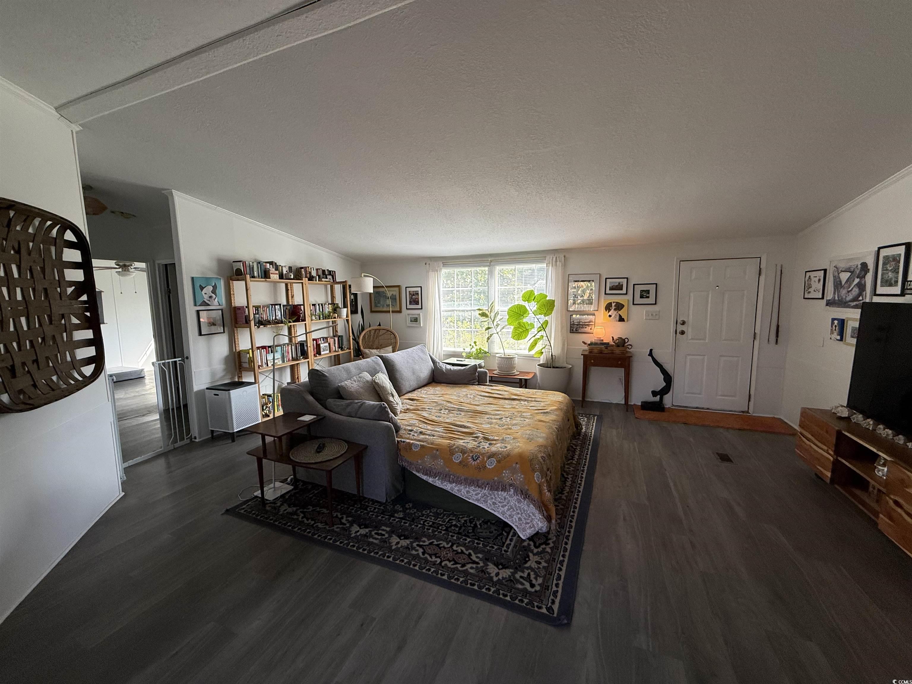 19 Gates Way Pawleys Island, SC 29585 - Photo 15 of 18 Living area with lofted ceiling, a textured ceiling, and dark wood-style floors