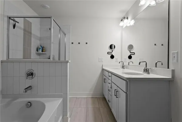 a spacious bathroom with a double vanity sink a mirror and a bathtub