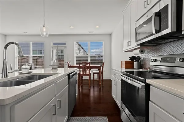 a kitchen with stainless steel appliances a sink stove and cabinets
