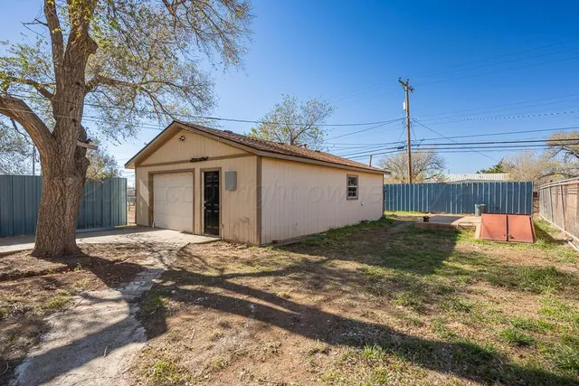 a view of a house with a yard and wooden fence