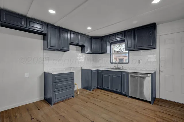 a kitchen with stainless steel appliances granite countertop wooden cabinets a stove top oven a sink and dishwasher