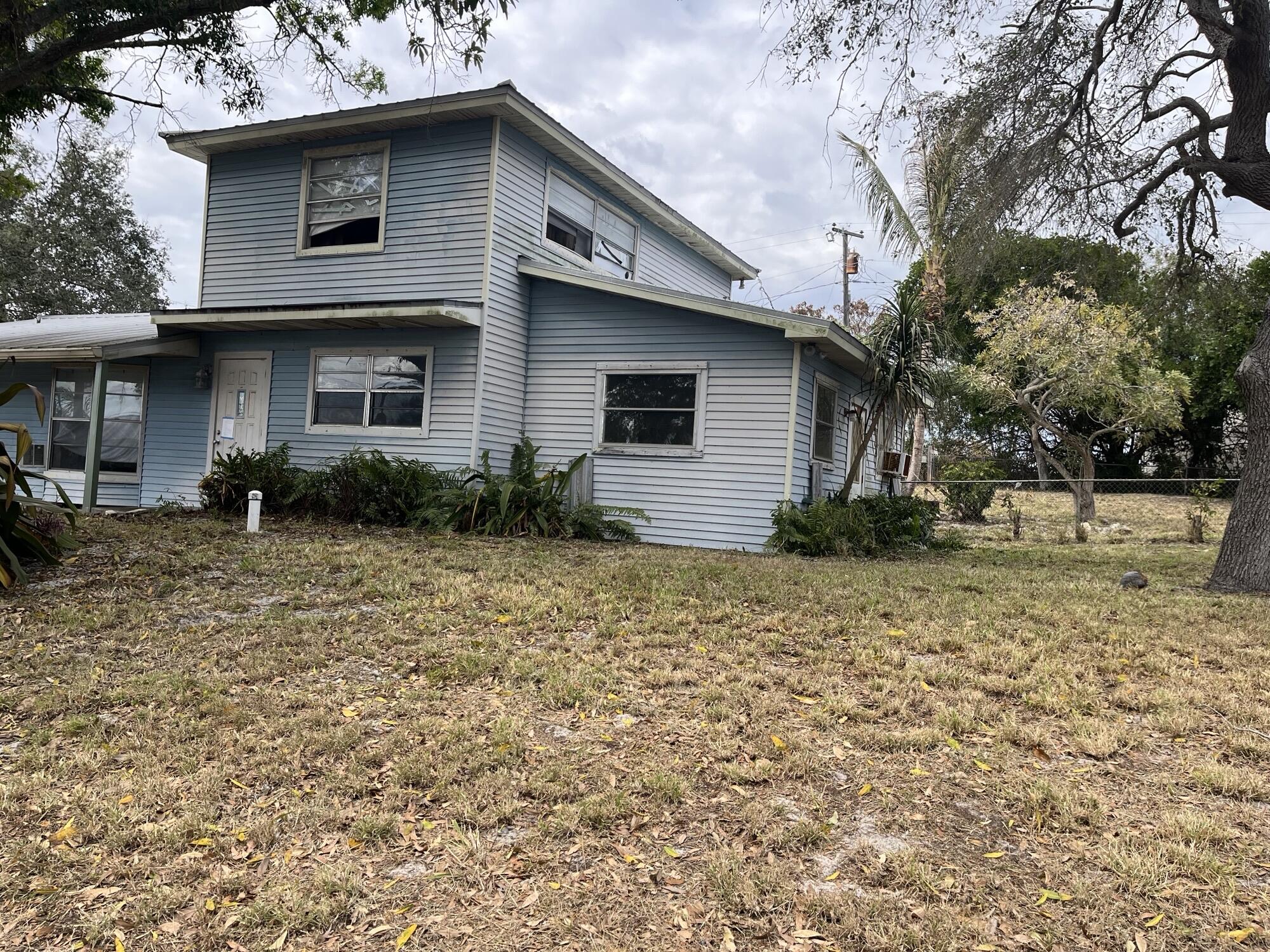 3211 Southeast Clayton Street Stuart, FL 34997 - Photo 1 of 3 a front view of a house with garden