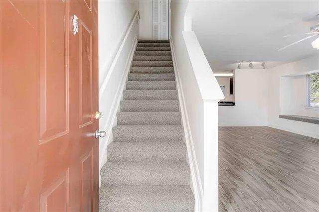 an empty room with windows and ceiling fan