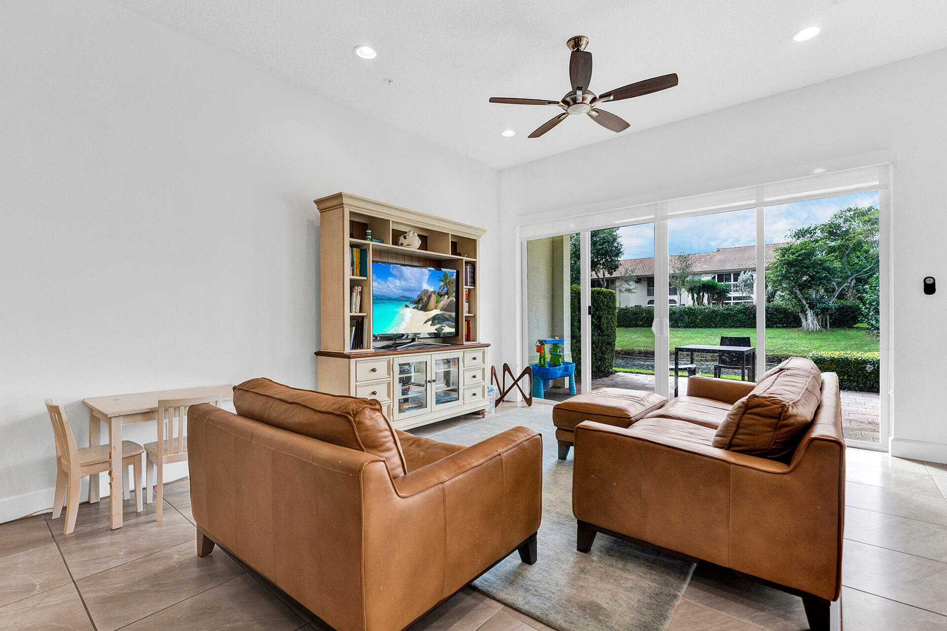 6640 Quiet Wave Trail, Unit 67 Boca Raton, FL 33433 - Photo 11 of 35 a living room with furniture ceiling fan and a floor to ceiling window