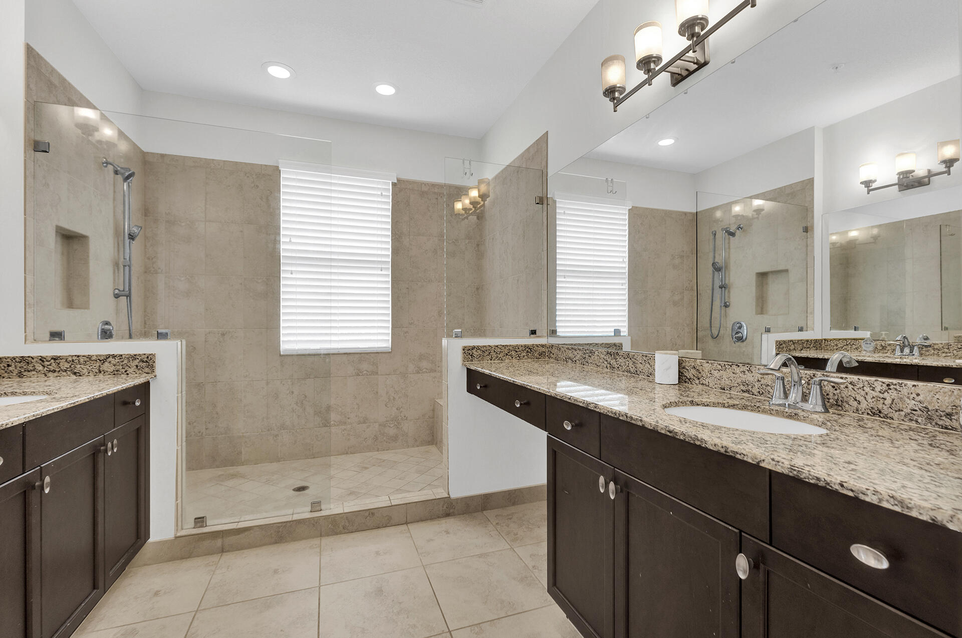 6640 Quiet Wave Trail, Unit 67 Boca Raton, FL 33433 - Photo 17 of 35 a bathroom with a granite countertop double vanity sink a mirror and a shower