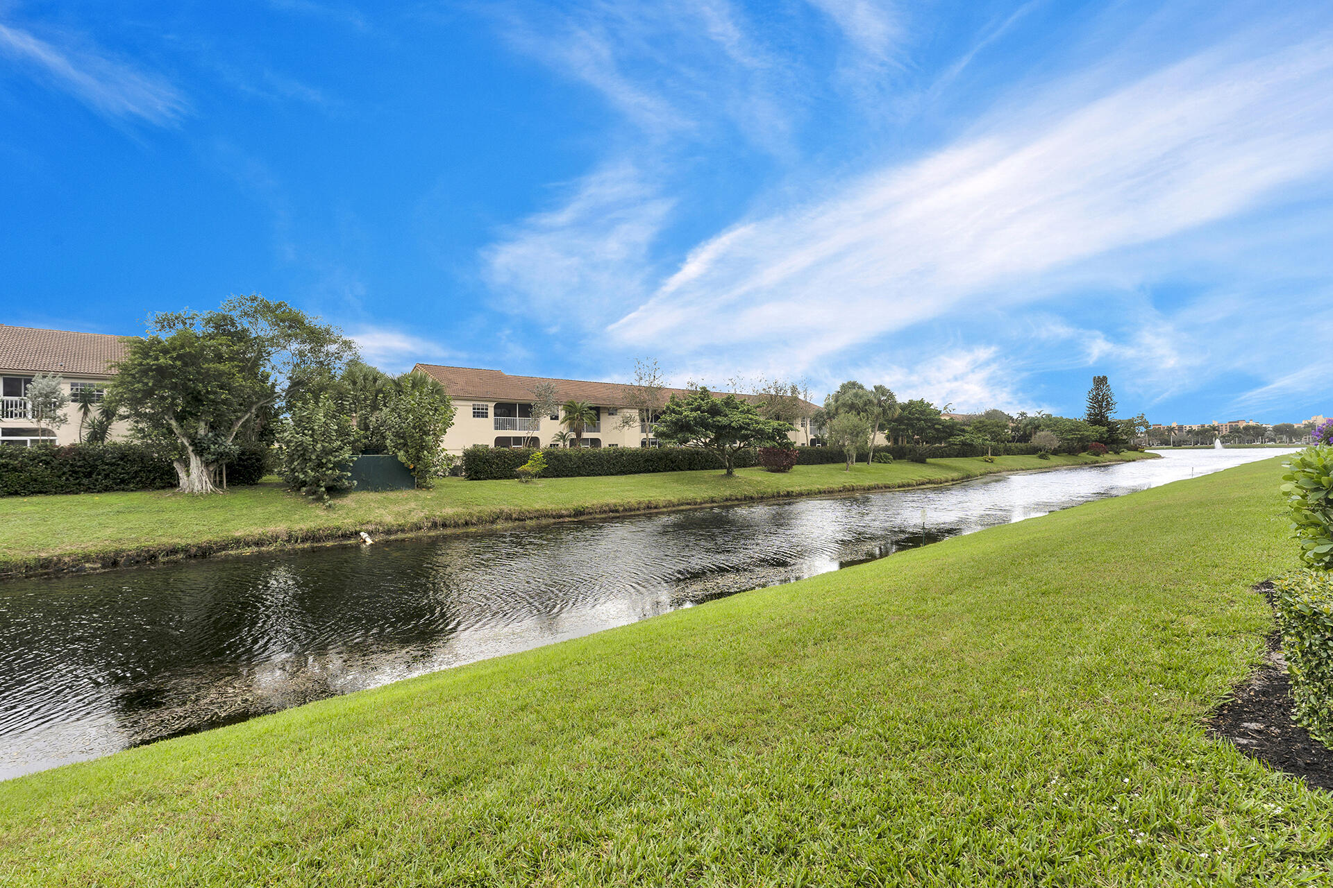 6640 Quiet Wave Trail, Unit 67 Boca Raton, FL 33433 - Photo 27 of 35 a view of a lake with houses in the background
