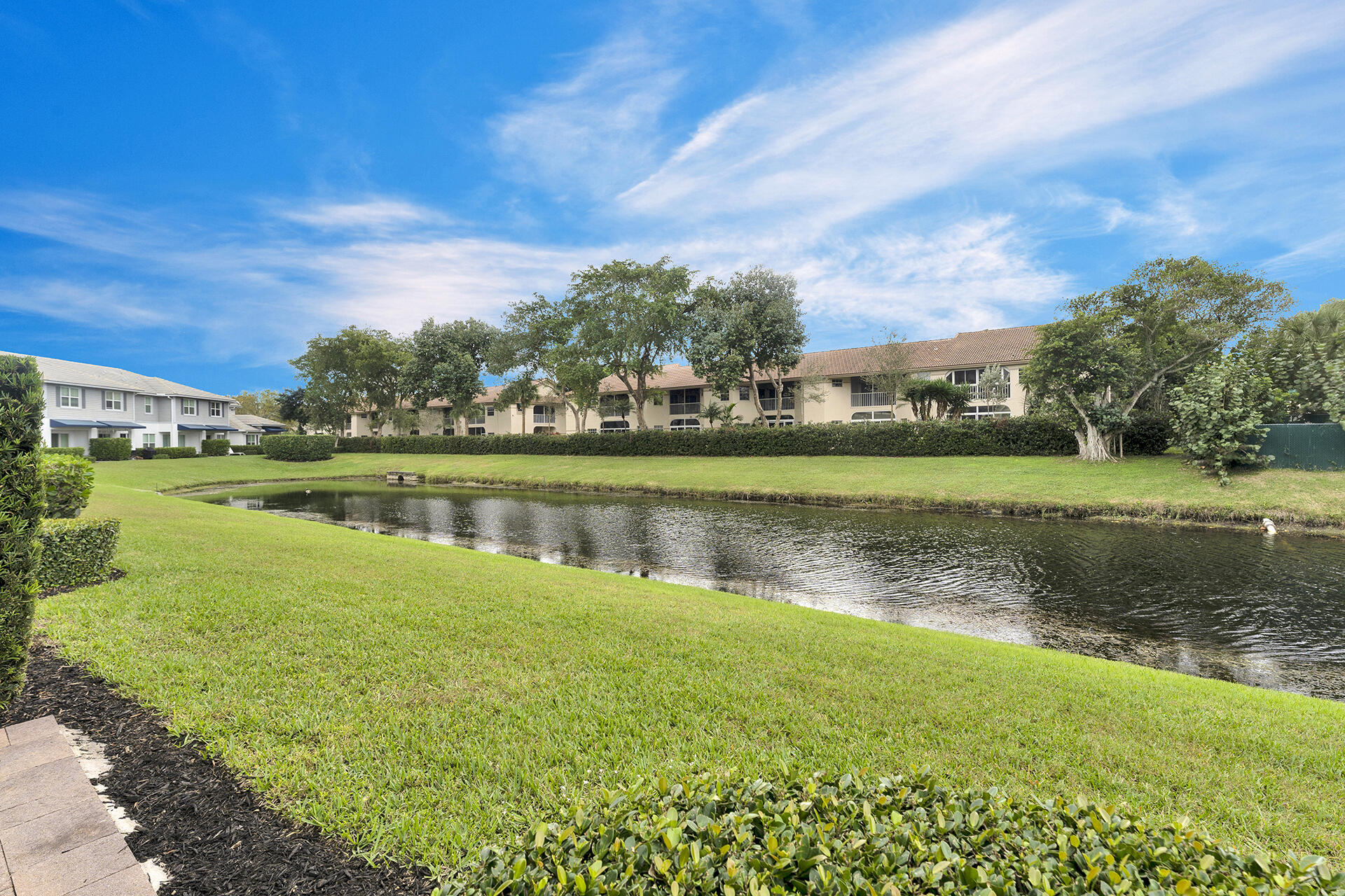 6640 Quiet Wave Trail, Unit 67 Boca Raton, FL 33433 - Photo 28 of 35 a view of a lake with houses in the background
