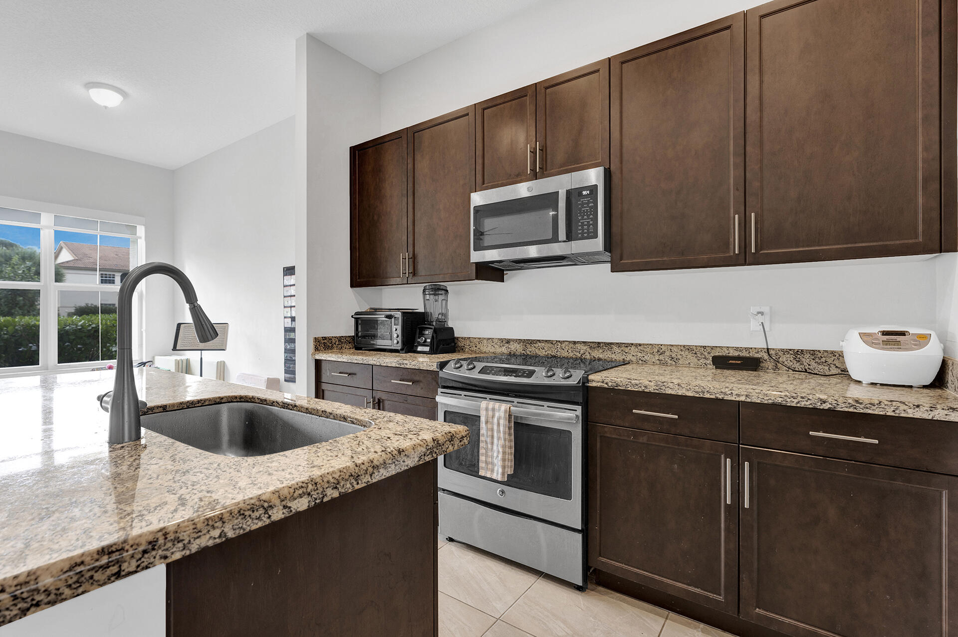 6640 Quiet Wave Trail, Unit 67 Boca Raton, FL 33433 - Photo 6 of 35 a kitchen with granite countertop a sink and a stove top oven