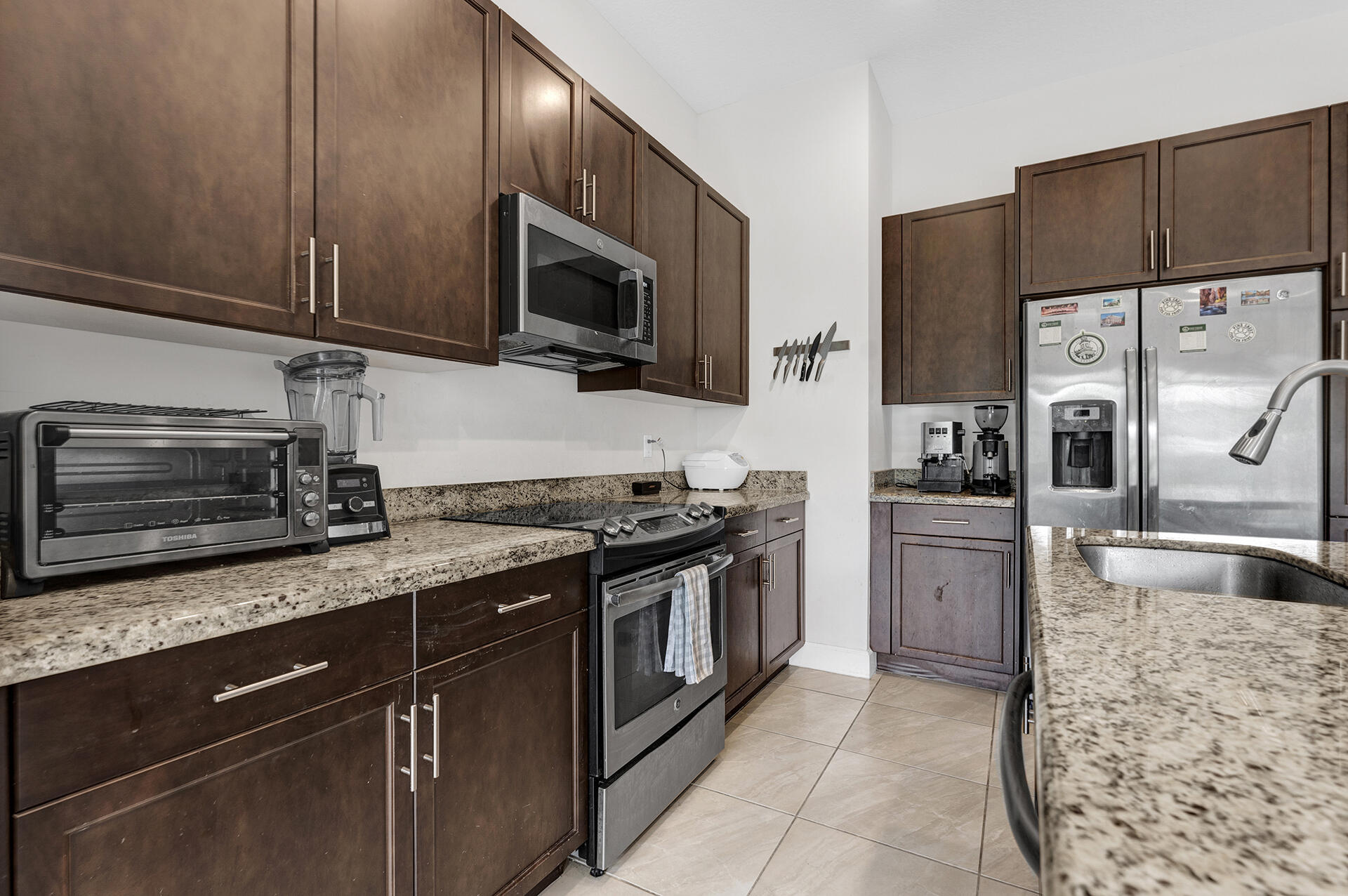 6640 Quiet Wave Trail, Unit 67 Boca Raton, FL 33433 - Photo 7 of 35 a kitchen with stainless steel appliances granite countertop a stove microwave and refrigerator