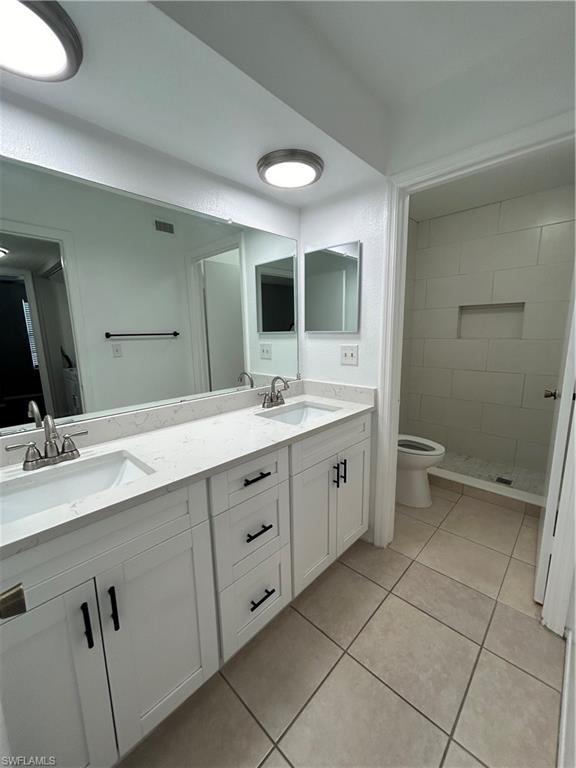 1989 Rookery Bay Drive, Unit 704 Naples, FL 34114 - Photo 8 of 10 Full bathroom featuring double vanity, light tile patterned flooring, and a shower stall