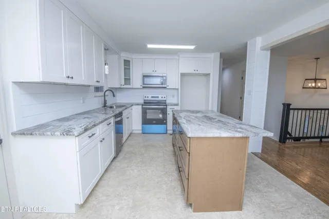 a kitchen with kitchen island a sink stove and refrigerator