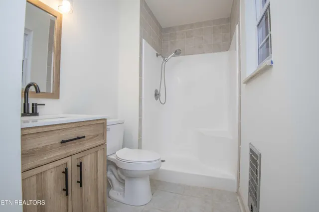 a bathroom with a shower toilet sink and mirror