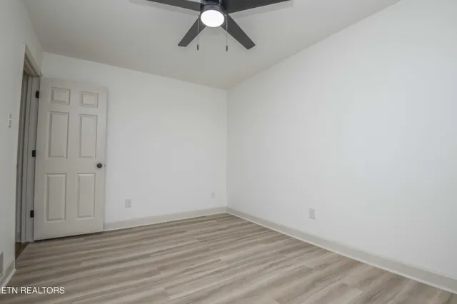 a view of a room with wooden floor and fan