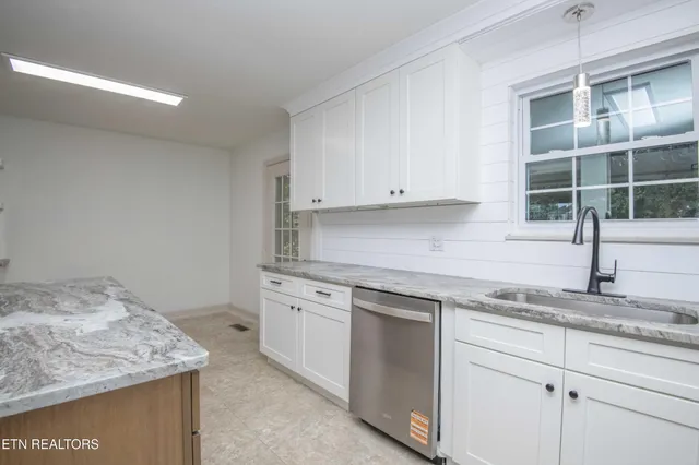 a kitchen with granite countertop a sink and cabinets