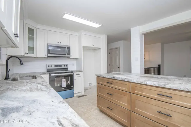a kitchen with sink a stove and cabinets