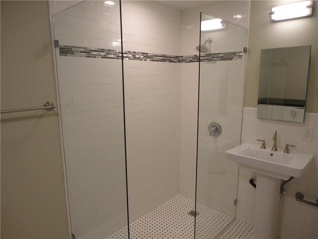 3311 Speedway, Unit D Austin, TX 78705 - Photo 17 of 23 The bathroom features a glass-enclosed shower with white subway tile and a decorative mosaic accent stripe