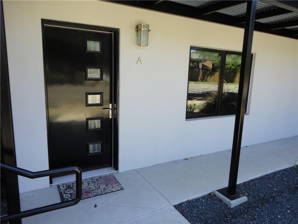 3311 Speedway, Unit D Austin, TX 78705 - Photo 4 of 23 The property features a contemporary black entry door with rectangular window panels, complemented by an exterior wall sconce