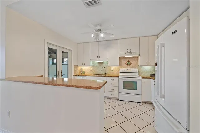 a kitchen with kitchen island granite countertop appliances cabinets and a counter top space