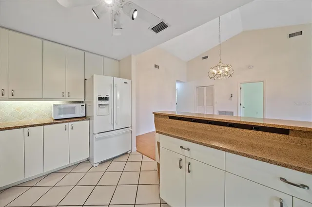 a kitchen with white cabinets and refrigerator