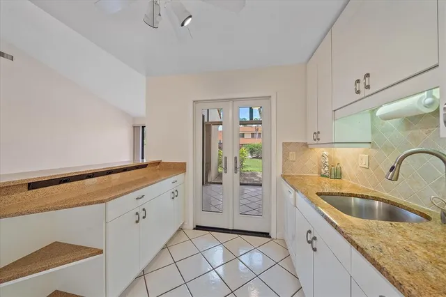 a kitchen with granite countertop a sink and a refrigerator