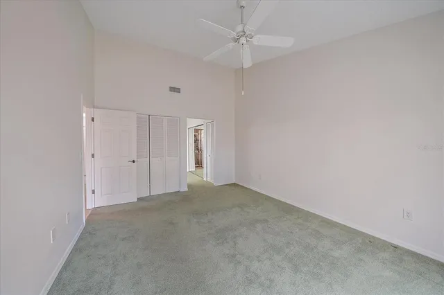 an empty room with a ceiling fan and a window
