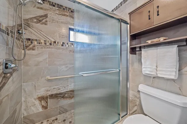 an empty room with windows and ceiling fan