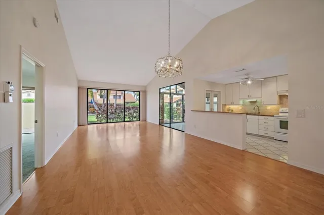 a view of an empty room with window and wooden floor