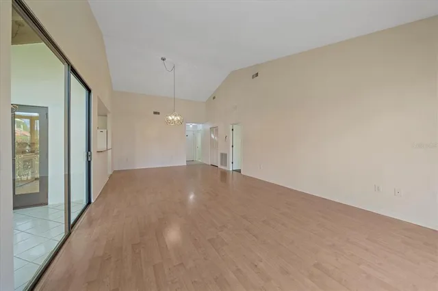 a view of a big room with wooden floor and windows