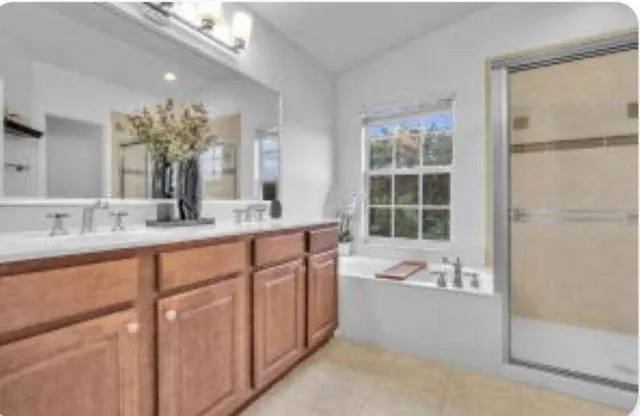 a bathroom with a granite countertop sink mirror and a bathtub