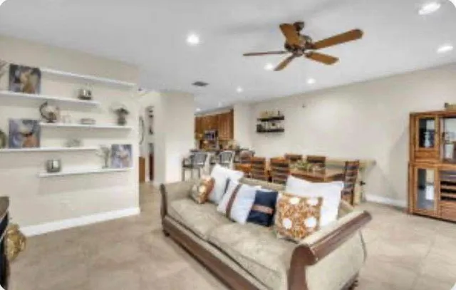 a living room with furniture kitchen view and a window