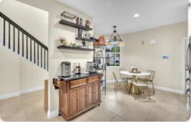 a kitchen with stainless steel appliances kitchen island granite countertop a table and chairs in it