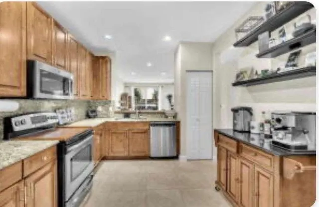 a kitchen with stainless steel appliances granite countertop a sink and cabinets