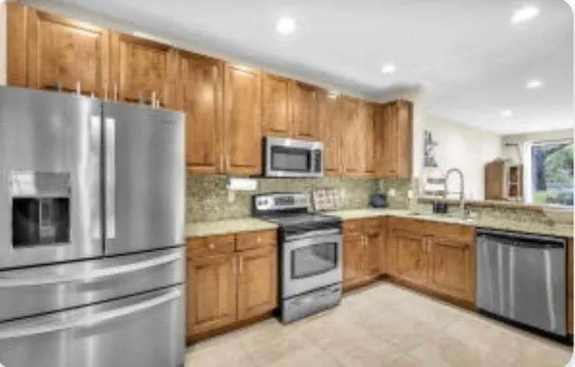 a kitchen with granite countertop stainless steel appliances and wooden cabinets