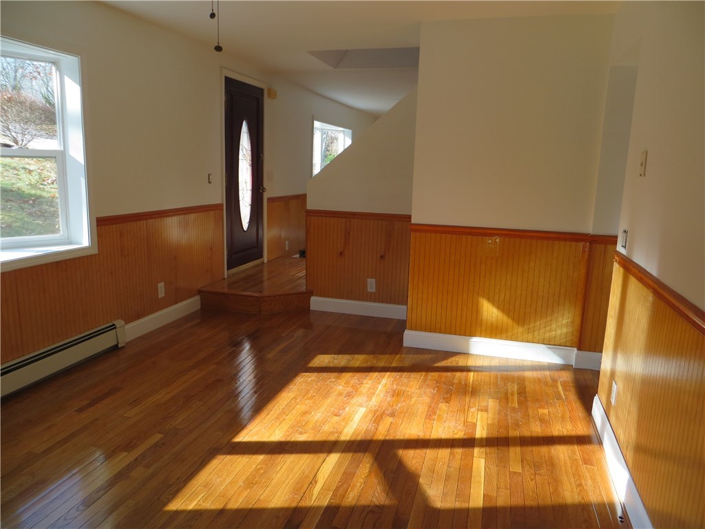 83 Columbia Heights Road Charlestown, RI 02813 - Photo 4 of 26 Living room showing front door, looking towards dinning room and door to hallway.