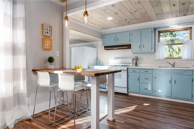 a kitchen with a table chairs refrigerator and wooden cabinets