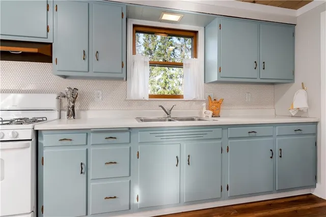 a kitchen with white cabinets and sink
