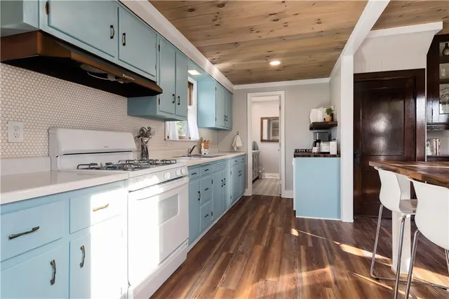 a kitchen with a sink a refrigerator and cabinets