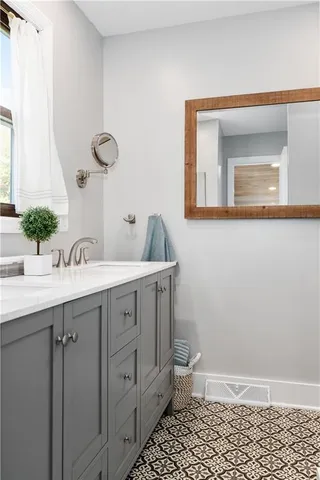 a bathroom with a double vanity sink and a mirror