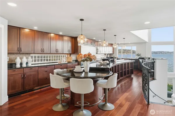 a kitchen with a table chairs stove and wooden floor