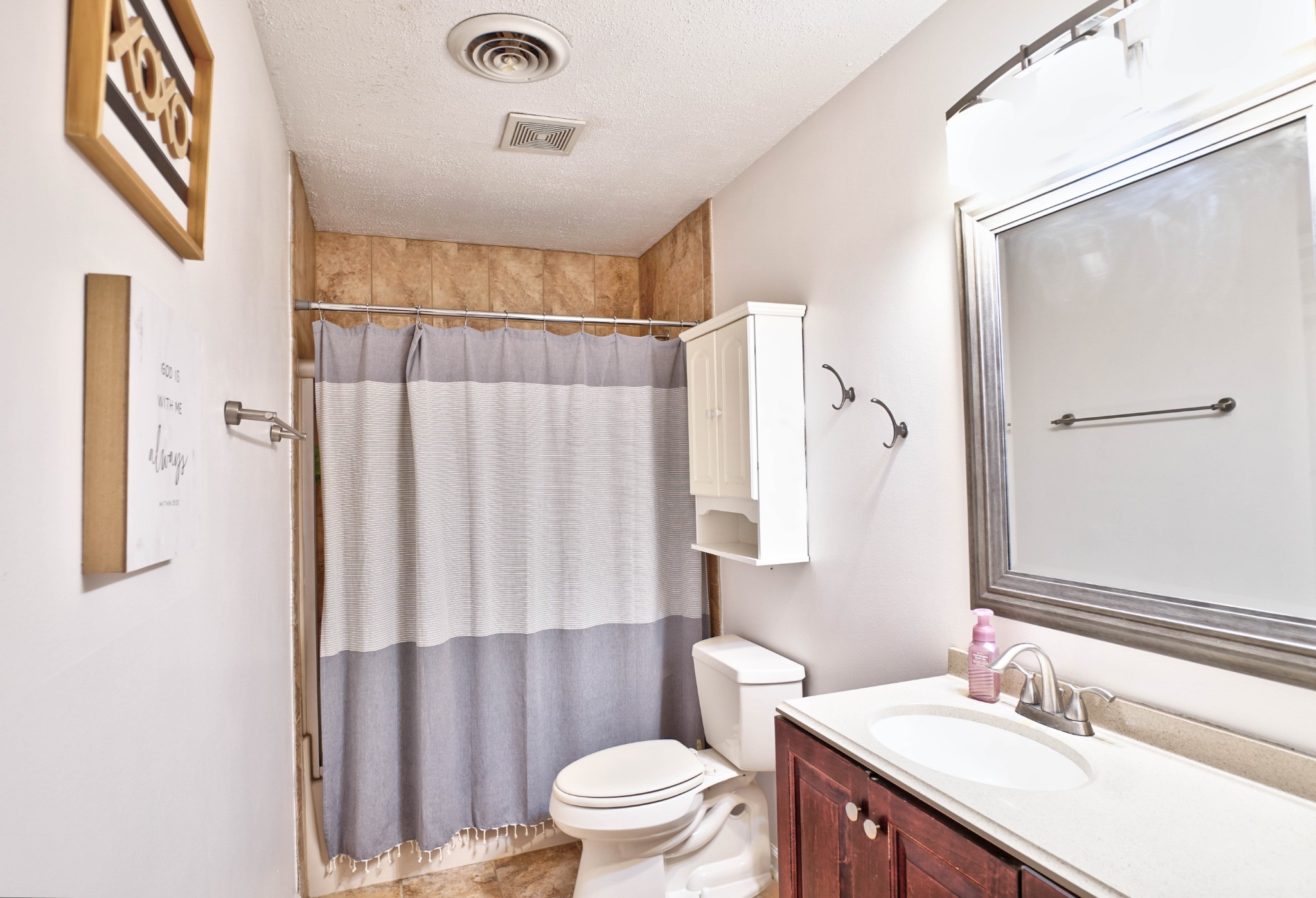 5871 Cane Ridge Road Antioch, TN 37013 - Photo 32 of 40 a bathroom with a sink a toilet a mirror and shower curtain