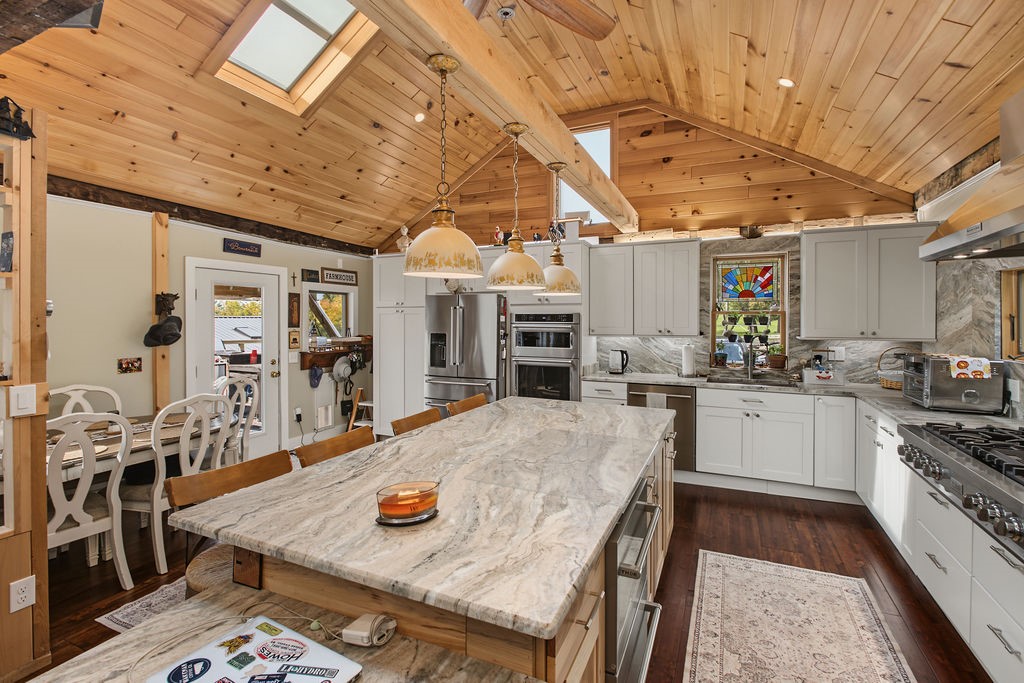 1668 Vandervort Hill Road Unadilla, NY 13849 - Photo 7 of 50 Gleaming stone countertops and a vaulted pine ceiling anchor this beautifully designed culinary space.