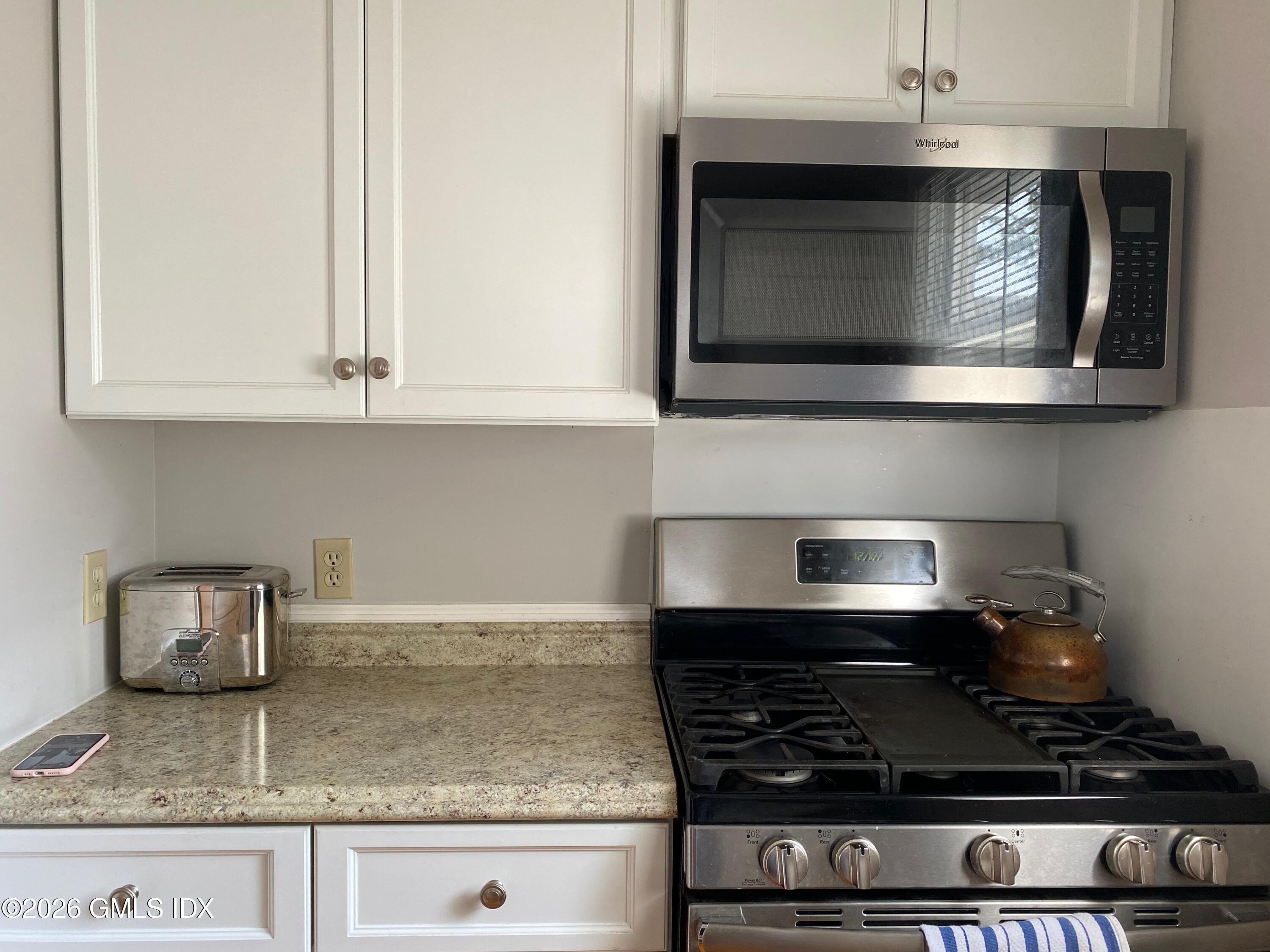 22 Division Street Greenwich, CT 06830 - Photo 12 of 29 a kitchen with granite countertop stainless steel appliances a stove and a microwave