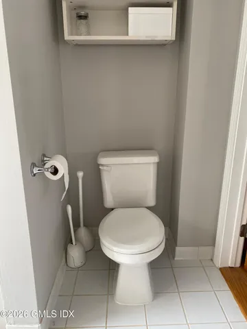 a white toilet sitting next to a shower