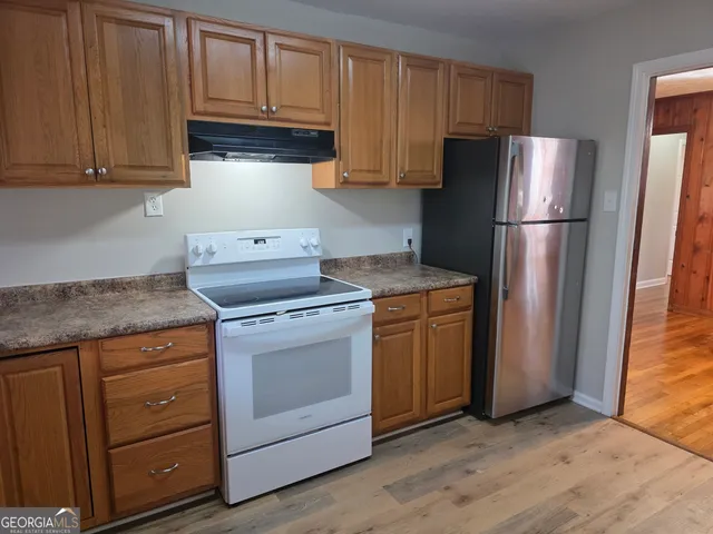 a kitchen with a refrigerator sink and cabinets