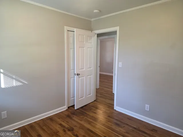 a view of an empty room with wooden floor