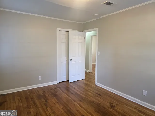 a view of an empty room with wooden floor