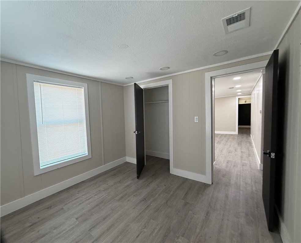 400 Austin Street George West, TX 78022 - Photo 18 of 23 a view of an empty room with wooden floor and a window
