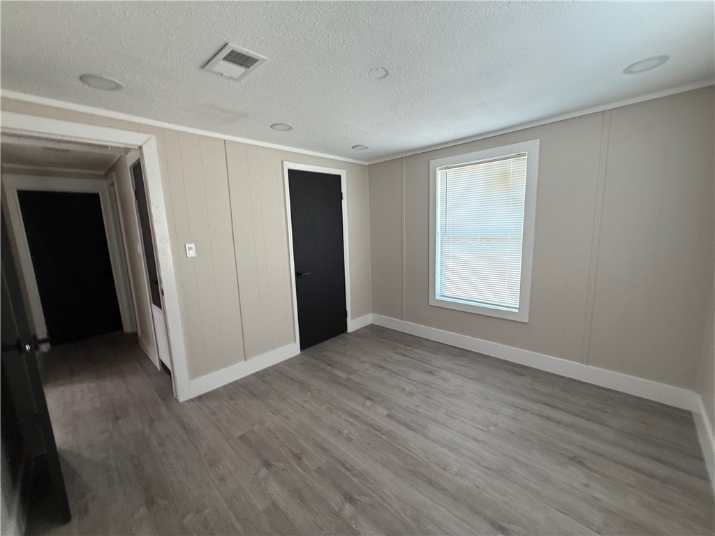 400 Austin Street George West, TX 78022 - Photo 4 of 23 a view of an empty room with wooden floor and a window