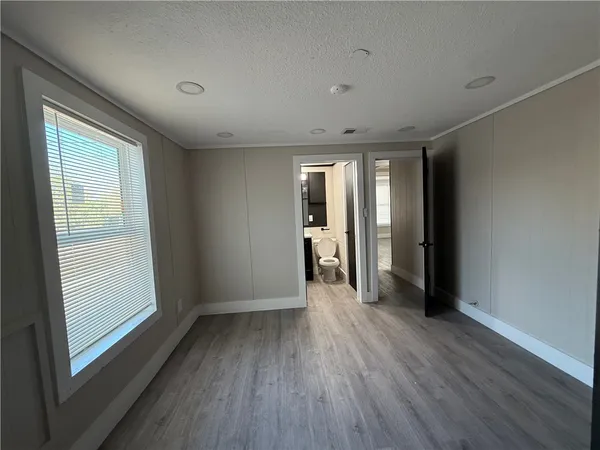 a view of hallway with a large window and wooden floor