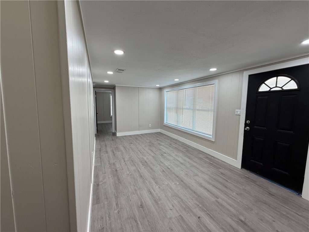 400 Austin Street George West, TX 78022 - Photo 5 of 23 a view of an empty room with wooden floor and a window